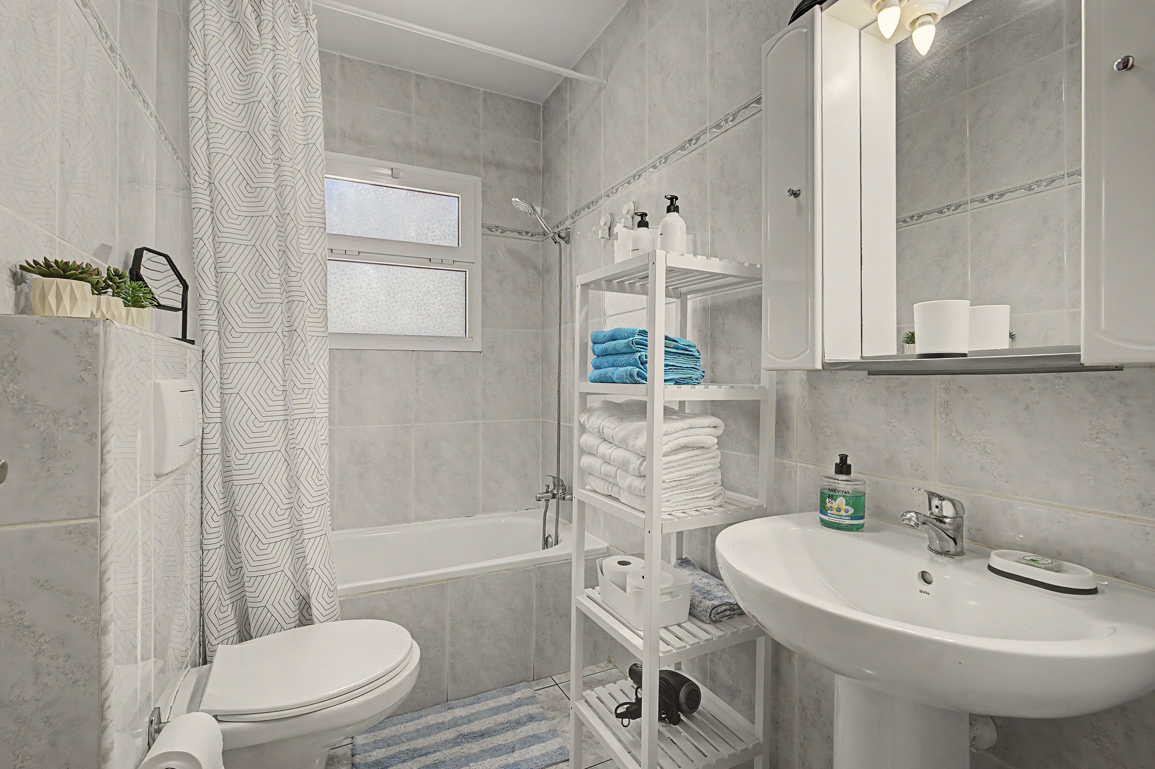 Ein modernes Badezimmer mit Toilette, Dusche, Waschbecken und Handtuchhalter.