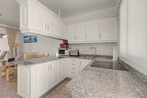 A kitchen with white cabinets, a red coffee maker, a toaster, and a sink. - Vacation Apartment 'Ansai Beach' with Sea View, Private Terrace and Wi-Fi (Costa Calma)