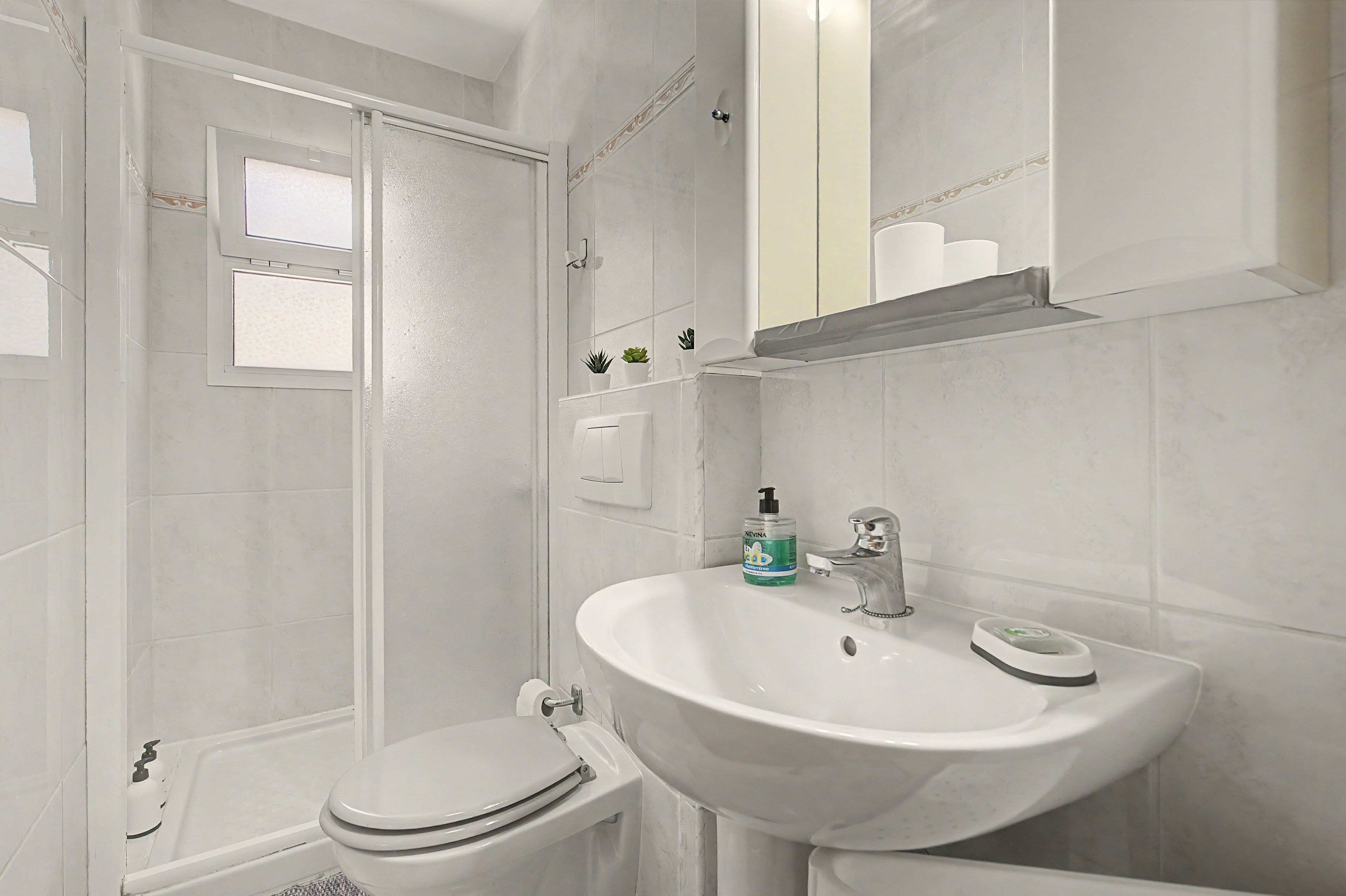 Une salle de bain avec des toilettes, un lavabo et une douche.