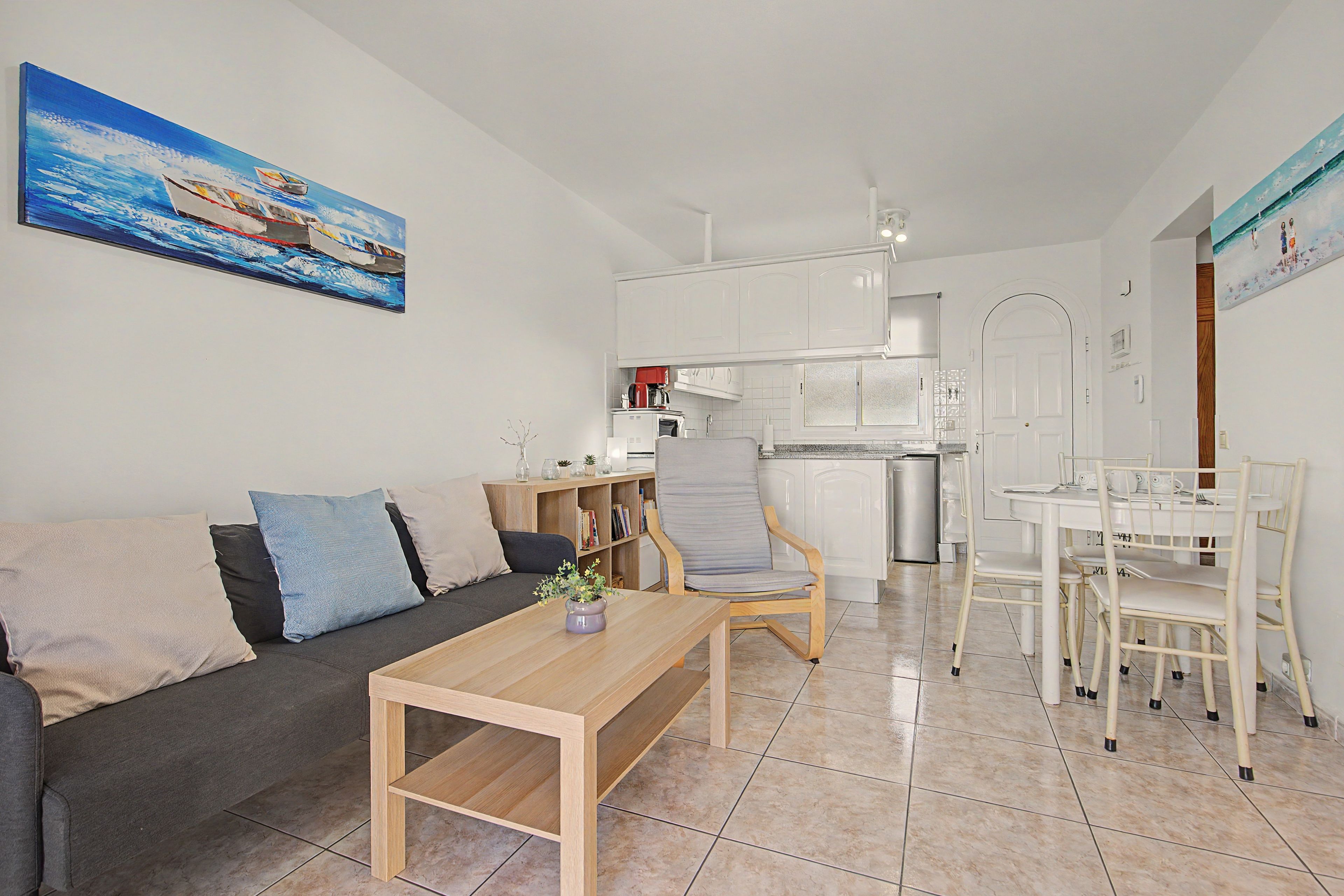 Un salon moderne comprenant un canapé, une table basse et un coin repas avec une table et des chaises.