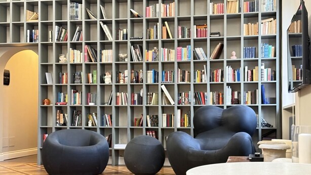 A library with bookshelves, black chairs, and a round table. - SE248 - Senigallia, three-room apartment in an elegant period building (Senigallia)