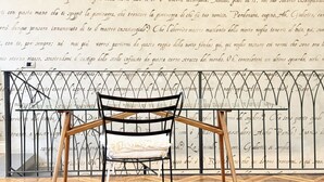 A chair and table in front of a wall with decorative script. - SE248 - Senigallia, three-room apartment in an elegant period building (Senigallia)