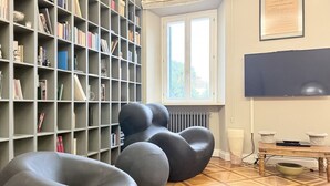 A room with a bookshelf, a radiator, a window, and a television. - SE248 - Senigallia, three-room apartment in an elegant period building (Senigallia)