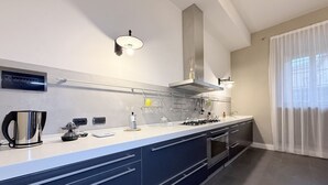 A modern kitchen with a white countertop, stainless steel appliances, and a large window with sheer curtains. - SE248 - Senigallia, three-room apartment in an elegant period building (Senigallia)