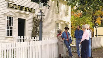 A historic building with a white picket fence and a sign reading 'Historic Deerfield.'