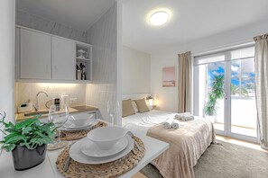 Een moderne hotelkamer met een keukenhoek, een bed met uitzicht en een eethoek.