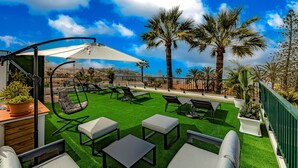An outdoor patio with artificial grass, seating, and a view of the city. - Studio with city view N8 (Puerto de la Cruz)