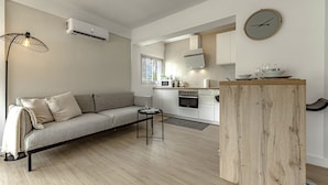 Une cuisine moderne dotée d’un four encastré, d’une table à manger et d’un élément décoratif en bois.