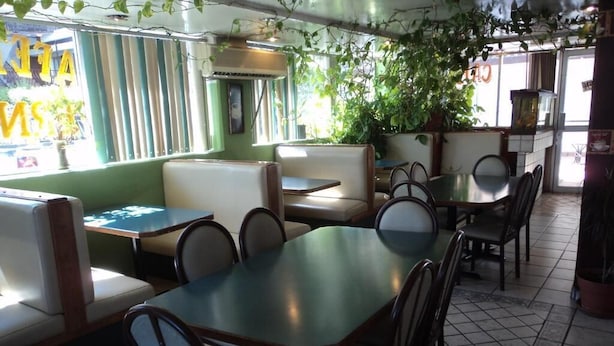 L’intérieur d’un restaurant, avec des banquettes, des tables et des chaises.