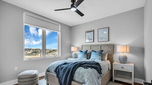 A bedroom with a bed, bedside tables, a window, and a ceiling fan. - Luxury 3BR with Seaside Views Jersey Shore Gem (Seaside Heights)