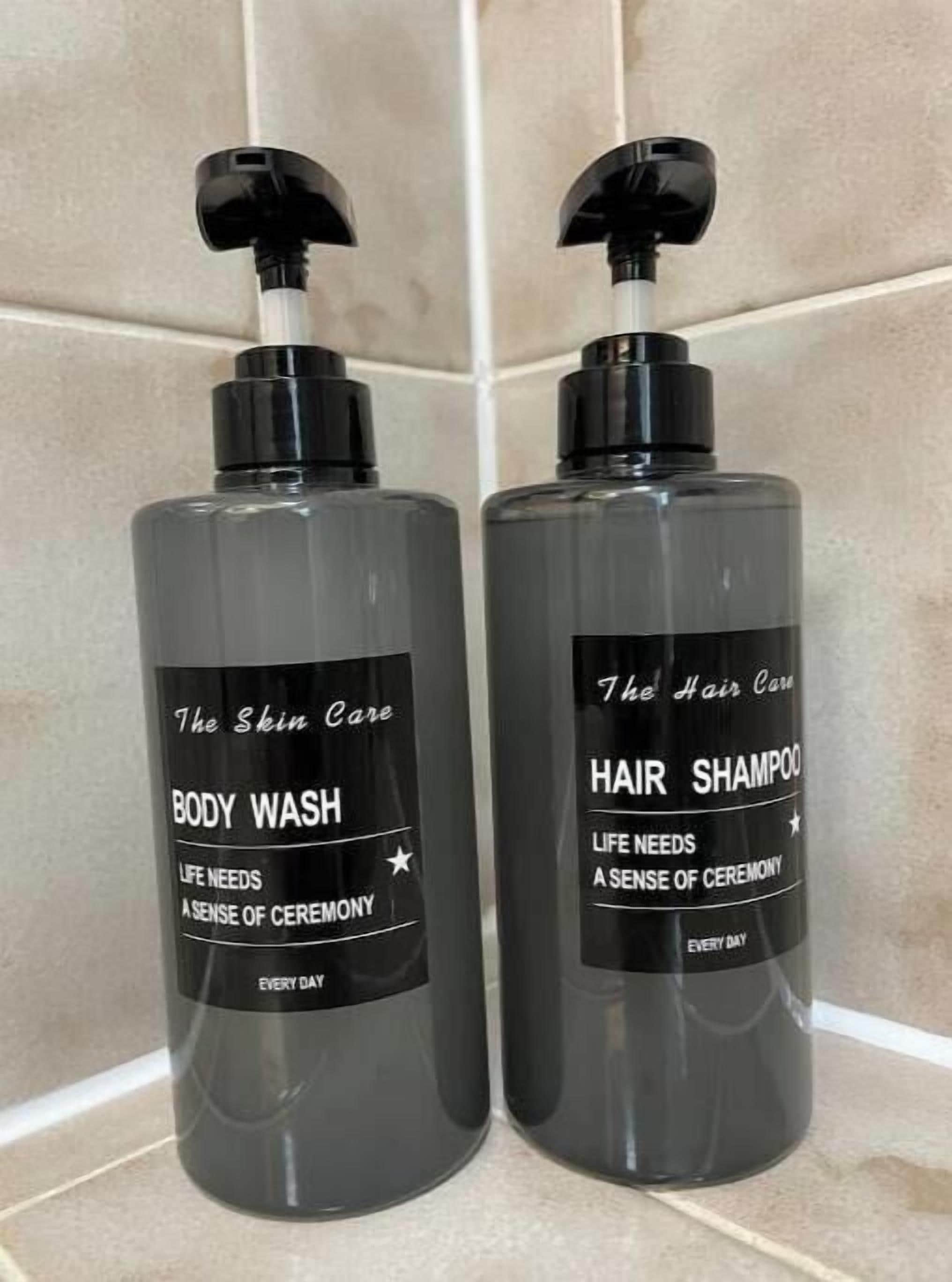 Due flaconi di bagnoschiuma e shampoo per capelli su una superficie piastrellata.