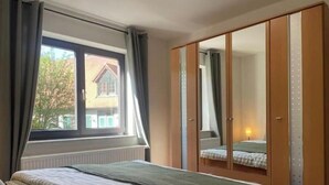 Un dormitorio con cama, ventana y armario.