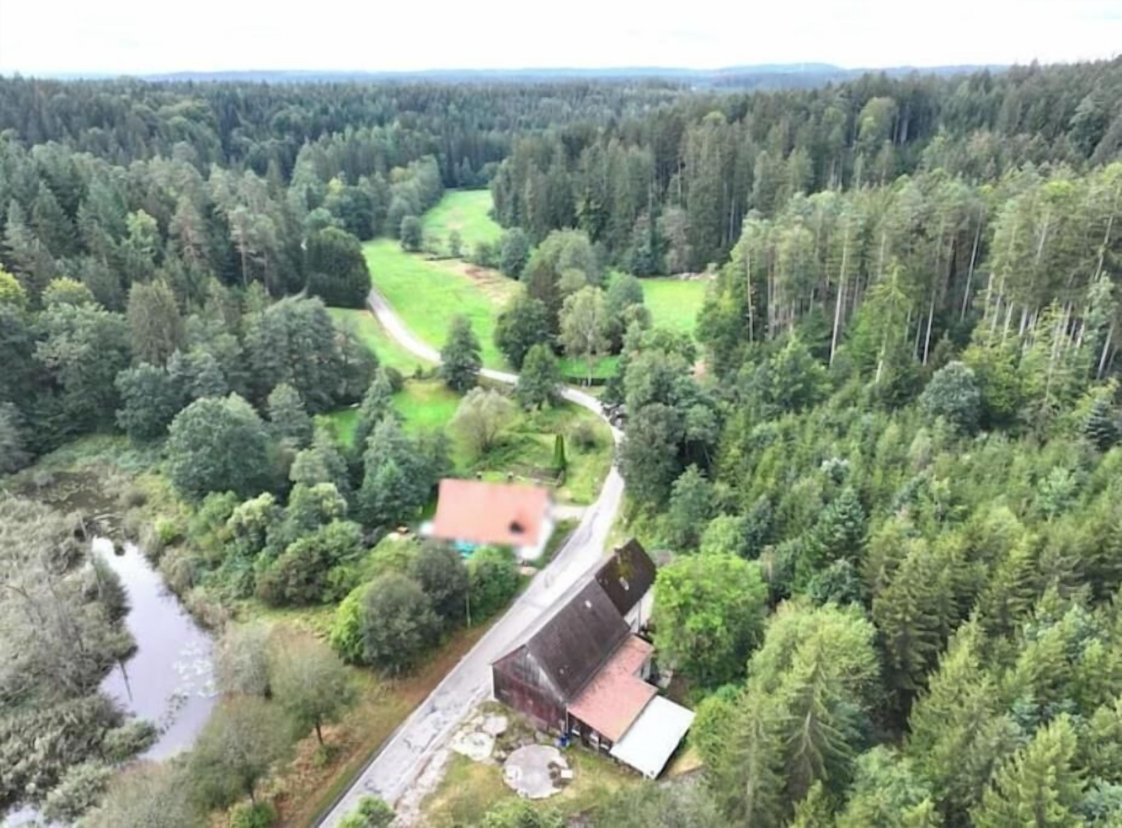Vue aérienne d’une zone rurale avec une maison, une route et une rivière.