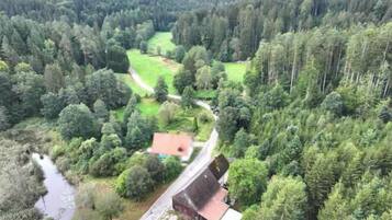 Vue aérienne d’une zone rurale avec une maison, une route et une rivière.