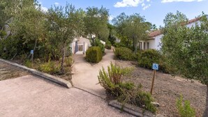 A pathway leading to a building with a wheelchair accessibility sign, surrounded by greenery and a clear sky. - Spacious Villa Stay for 6, Solenzara (Sari-Solenzara)