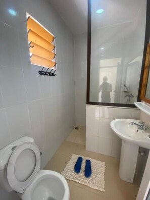Habitación individual Deluxe | Baño | Regadera, pantuflas, toallas, jabón 
