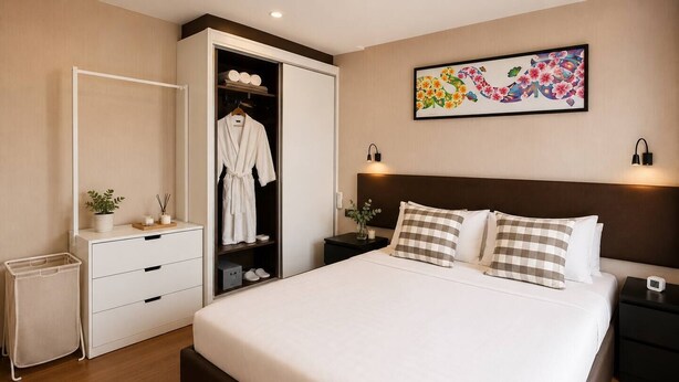 Una camera d'albergo con un letto, un armadio, un comodino e un'opera d'arte appesa al muro.
