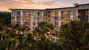 A multi-story hotel with balconies, a swimming pool, and lush greenery. - Cozy 1br in Rawai Quiet Area balcony&fast wi-fi (Rawai)