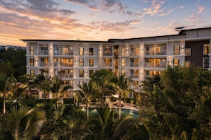 A multi-story hotel with balconies, a swimming pool, and lush greenery. - Cozy 1br in Rawai Quiet Area balcony&fast wi-fi (Rawai)