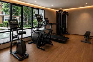 A modern gym with cardio machines, a squat rack, and a bench. - Cozy 1br in Rawai Quiet Area balcony&fast wi-fi (Rawai)