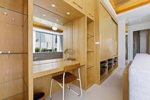 Un dormitorio moderno con un escritorio de madera, un espejo y almacenamiento empotrado.