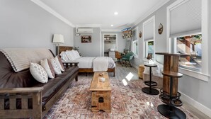 A modern living room with a sofa, a wooden coffee table, a desk, and a chair. - Petite Retreat at Harper's Ferry (Bolivar)