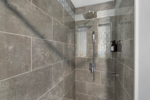 Een douche, handdoeken, zeep, toiletpapier