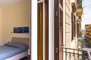 Ein Schlafzimmer mit einem Bett, einem Nachttisch und einem Stadtbild.