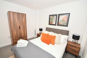 Ein Schlafzimmer mit einem Bett, einem Kleiderschrank, zwei Nachttischen und zwei Wandleuchten.