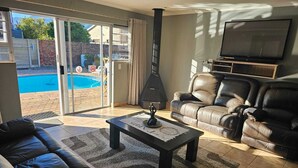 Ein Wohnzimmer mit Sofa, Couchtisch, Fernseher und Kamin.