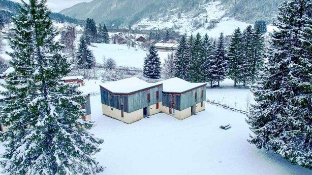 A snow-covered landscape with two buildings, surrounded by evergreen trees and a mountainous backdrop. - Mountain Flat With Pool in Lelex (Lelex)