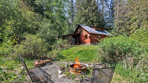 A cabin with a fire pit and outdoor seating.