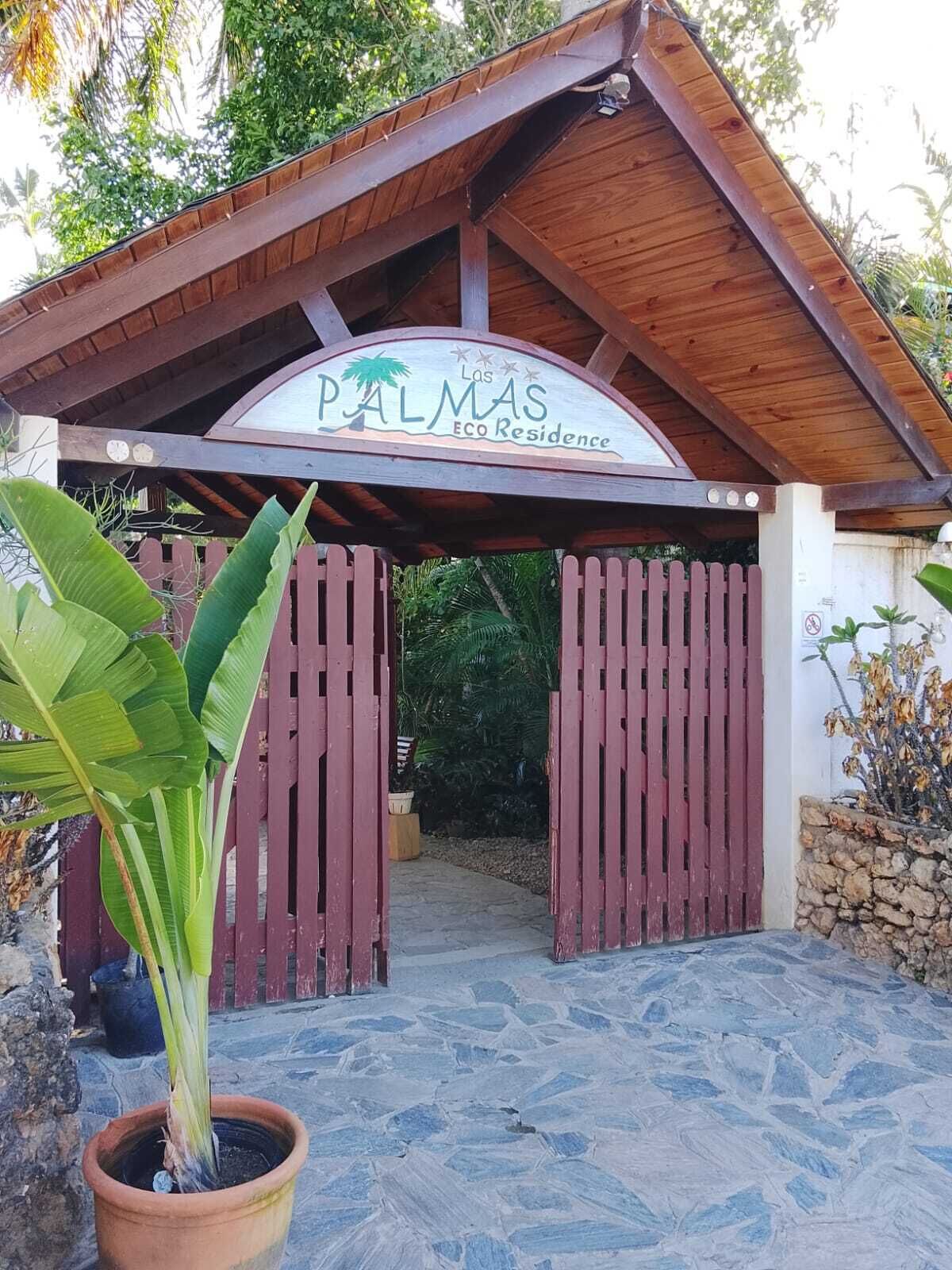 A wooden structure with a sign reading 'PALMAS ECO Residence.'