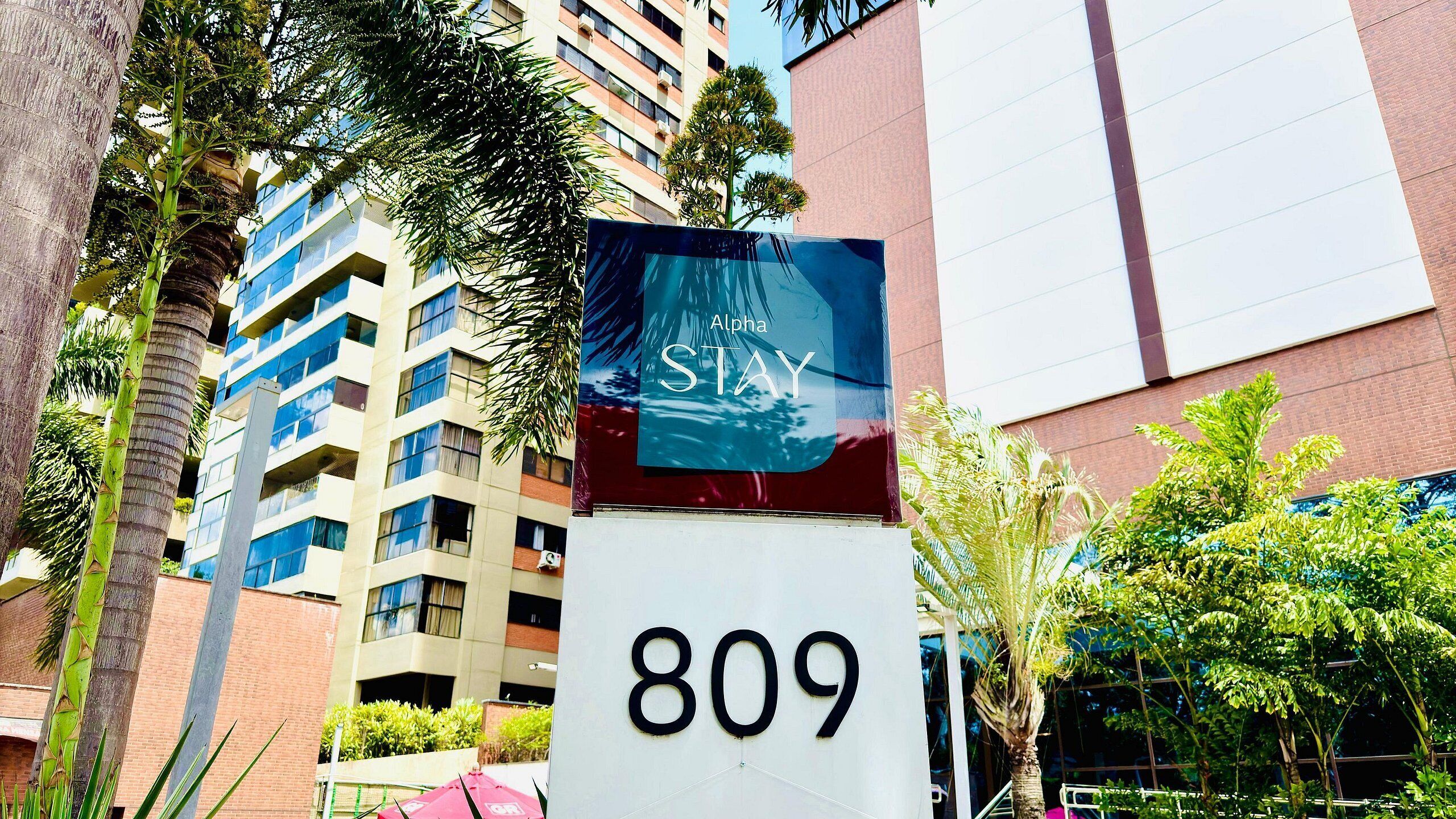 Ein Hotelschild mit der Nummer 809 und einem teilweisen Blick auf ein mehrgeschossiges Gebäude mit Balkonen.