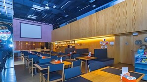A modern restaurant with high ceilings, wooden paneling, and a bar area. - Prime - Flats - Alpha Stay (Barueri)