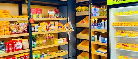 Une épicerie dont les rayons sont étiquetés comme suit : PRODUITS ALIMENTAIRES, FRUITS ET LÉGUMES, et PRODUITS CONGELÉS.