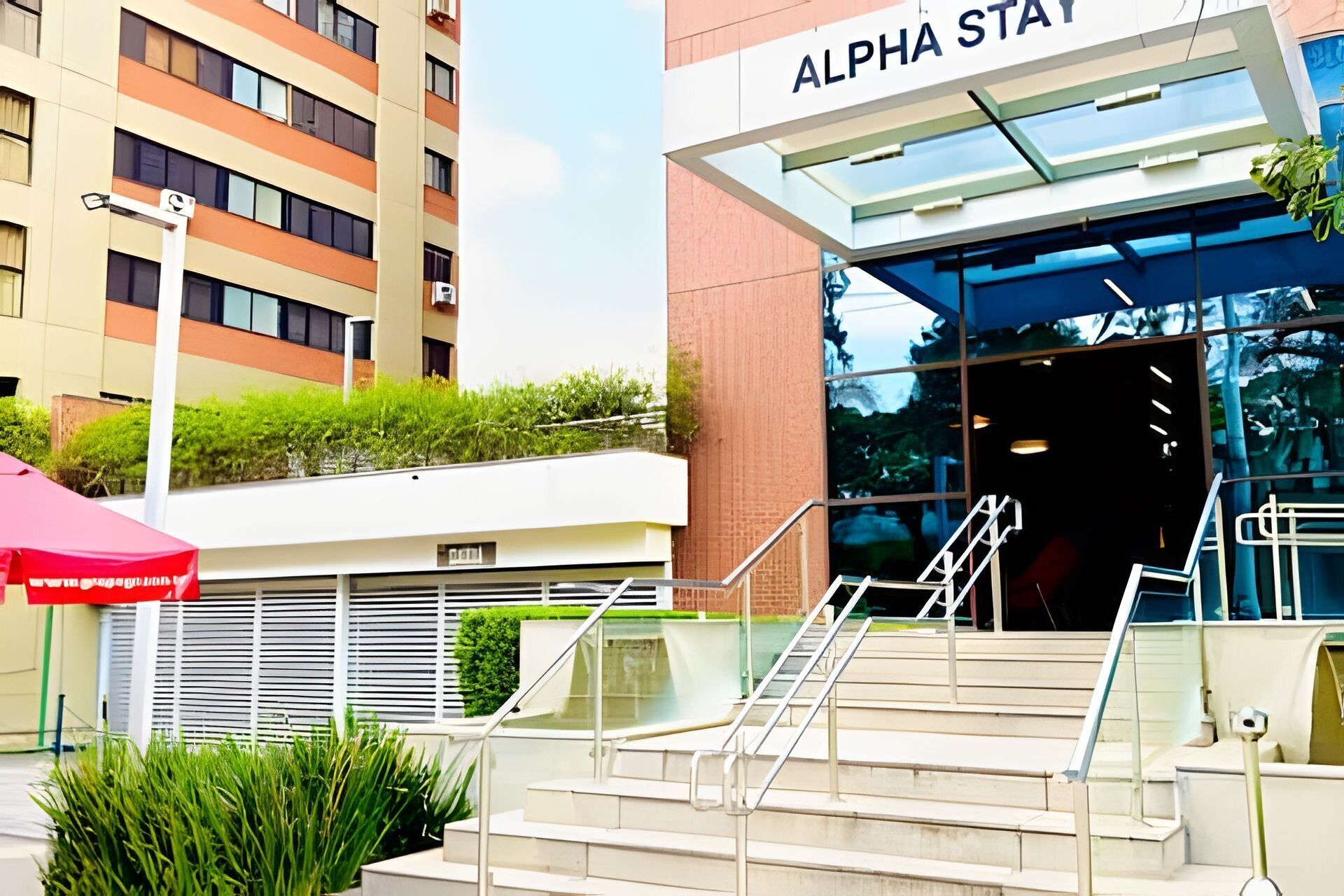 Un bâtiment moderne, sur lequel on peut lire l’inscription « ALPHA STAT », et un escalier extérieur menant à l’entrée.