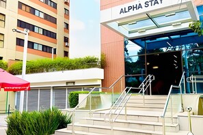 Entrada de un edificio moderno con un letrero que dice 'ALPHA STAT'.