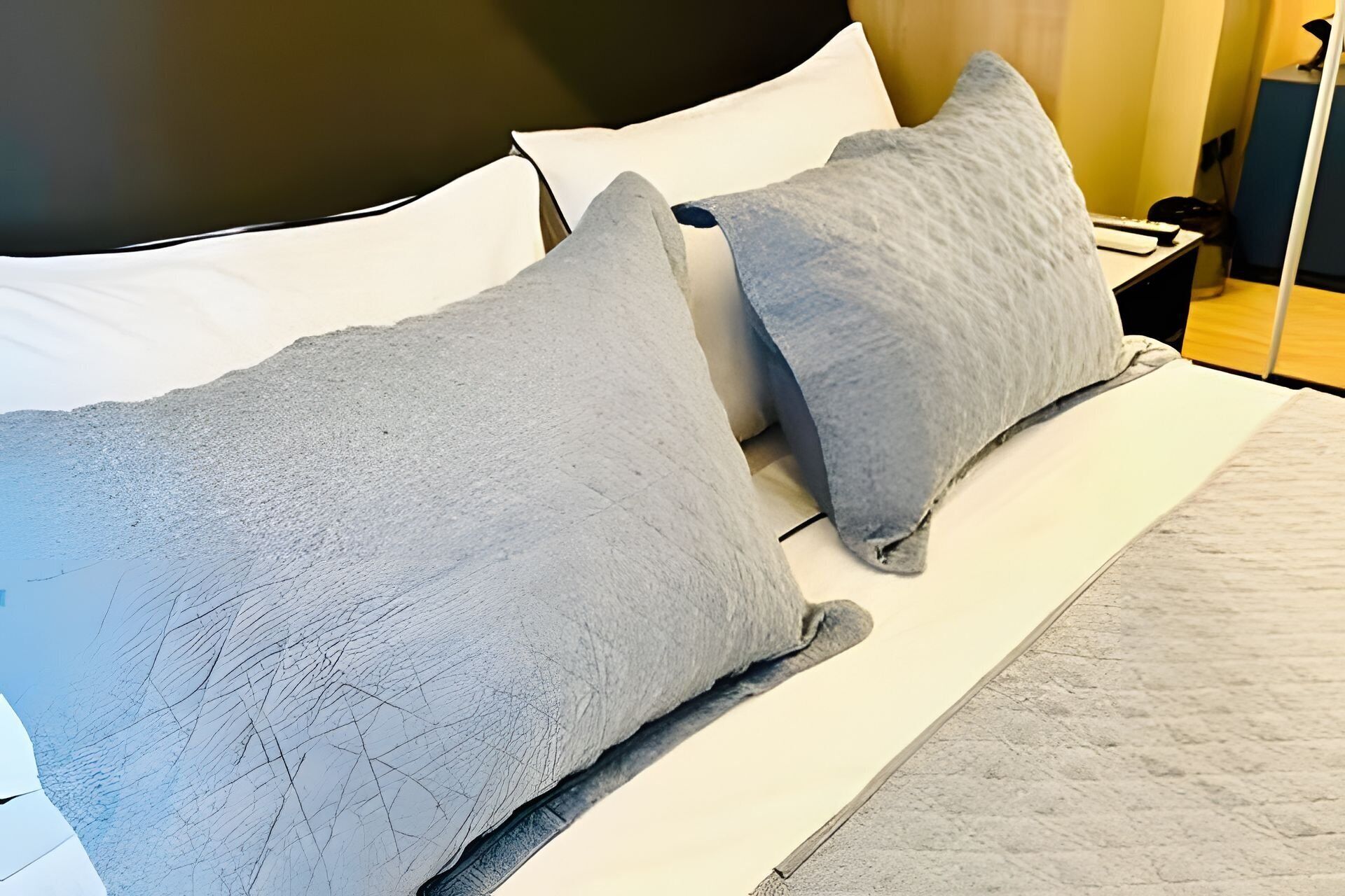 A bed with two pillows and a white mattress.