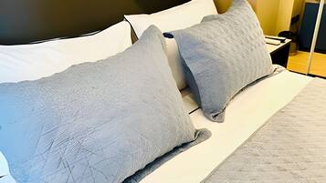 A bed with two pillows and a white mattress.