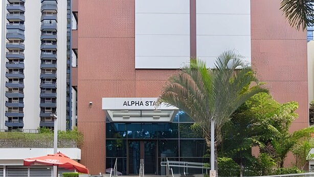 A modern building with a sign reading 'ALPHA ST' and a staircase leading to the entrance. - Prime - Flats - Alpha Stay (Barueri)