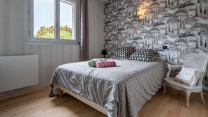 Une chambre à coucher avec un lit, une chaise, un radiateur et une fenêtre.