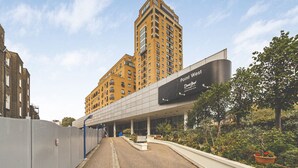 A modern building with a large sign for 'Point West' and 'David Lloyd' on the facade. - Stylish 3-Bed Apartment in South Kensington (Greater London)
