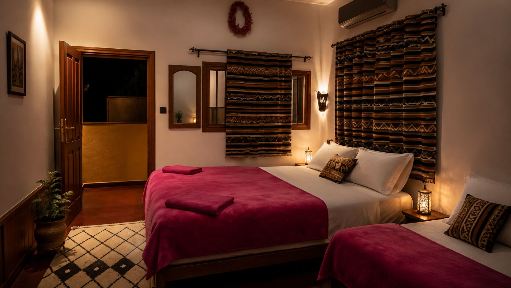 Een hotelkamer met een bed, nachtkastje, spiegel aan de muur, een deur en een plant in pot.
