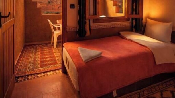 Une chambre avec un lit, une vue sur les montagnes, une fenêtre avec des rideaux et un escalier menant à un espace extérieur.