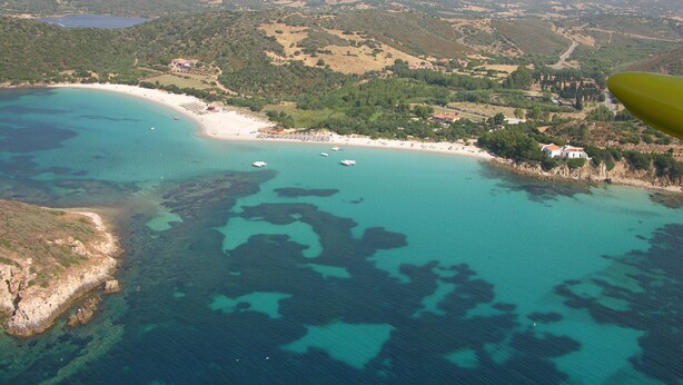 An aerial view of a coastal area with a beach, boats, and surrounding hills. - Casa Iride - a breath away from the sea
A stone's throw from paradise (Chia)