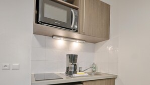 A compact kitchen with a microwave, coffee maker, and dishwasher. - Comfortable Studio for 2 by the Marne (Nogent-sur-Marne)