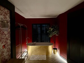 A modern bathroom with a gold bathtub, a shower, and a potted plant. - Boutique Studio Gold Bath in Jewellery Quarter BHM (Birmingham)