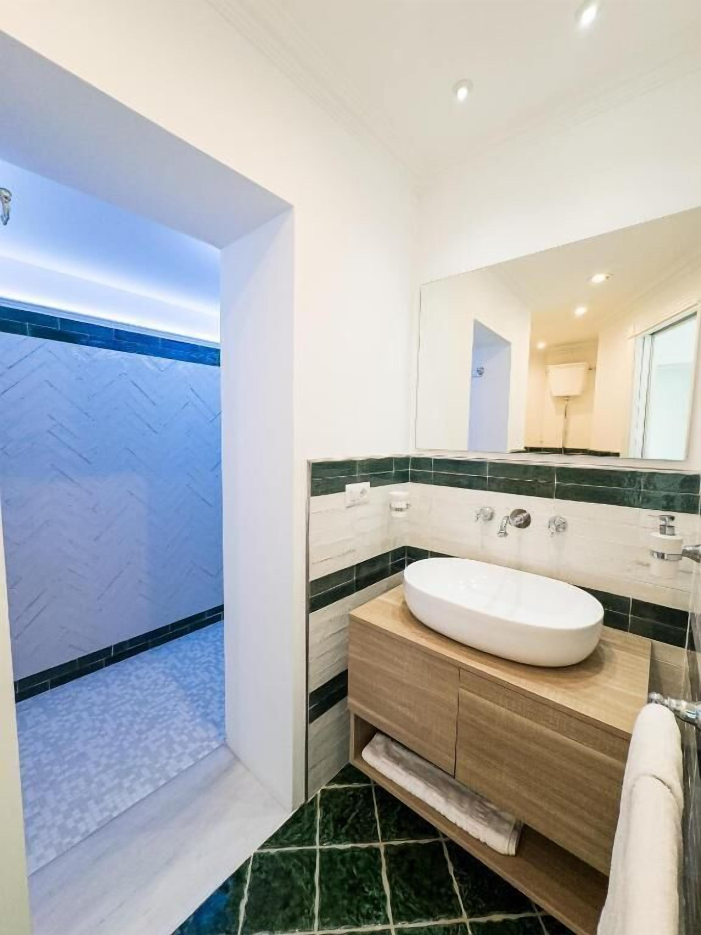 Doppia Deluxe, balcone, vista mare | Banheiro | Produtos de toalete grátis, secador de cabelo, chinelos 