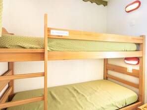 A bunk bed with a label, a red light fixture, and a green polka dot bedspread. - Alpine Stay for Four With Balcony (La Léchère)